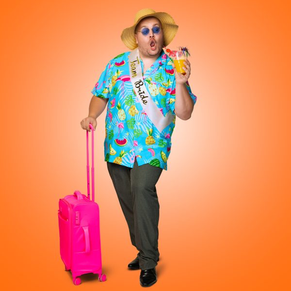 Cast image of Scott Paige. Scott is dressed in a Hawaiian shirt, rolling a bright pink suitcase, wearing a Team Bride sash with a straw hat and drinking a fruity cocktail.